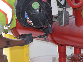 Man servicing pipe connected to fire protection system